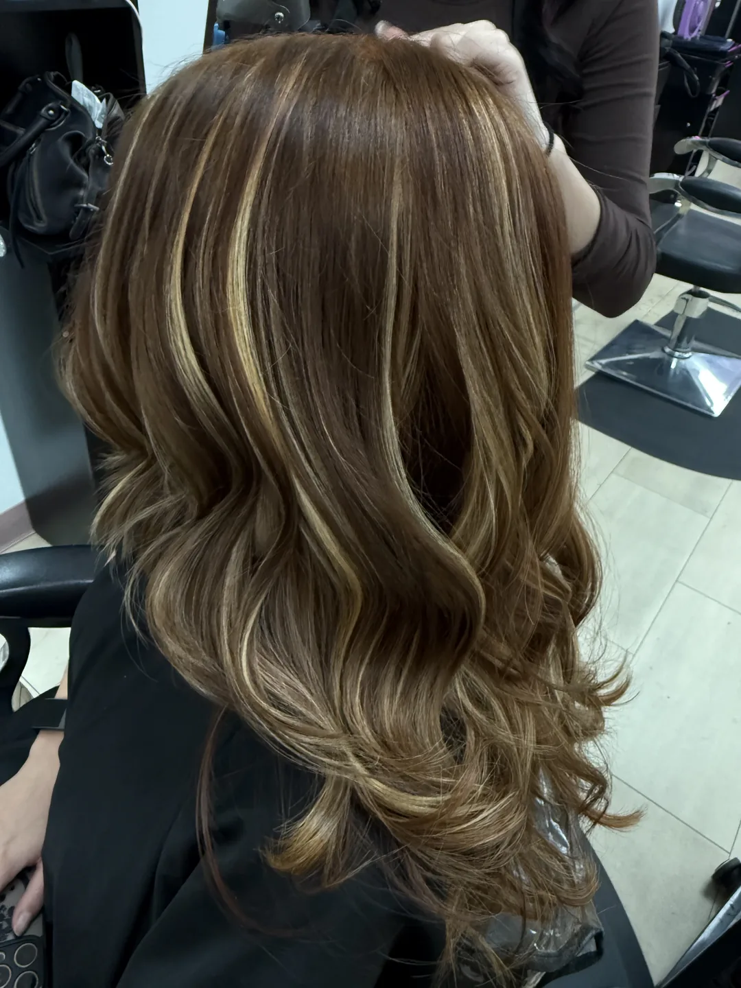 subtle blonde balayage on brunette waves, back view